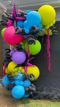 balloons and streamers are hanging from the side of a house in front of a door