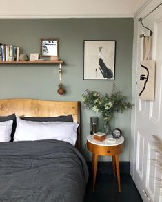 a bed sitting in a bedroom next to a wall with pictures hanging on the walls