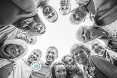 a group of people standing in a circle looking up at the camera with smiles on their faces