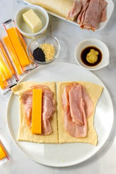 two slices of bread with cheese and ham on them, surrounded by ingredients for making an appetizer