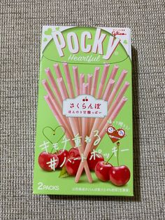 a package of pink candy sticks with cherries on them sitting on a carpeted surface