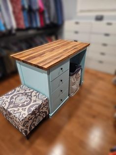 a small desk with drawers and a footstool in front of it on a hard wood floor