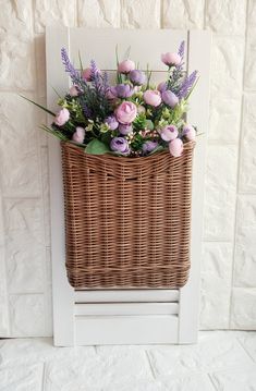 a basket filled with flowers sitting on top of a wall