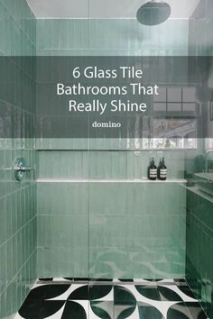 a bathroom with black and white tiles on the floor, green glass shower stall and bathtub