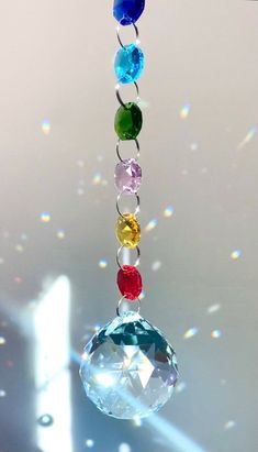 a multicolored glass wind chime hanging from a ceiling with bubbles in the background