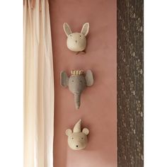 three stuffed animals are hanging on the wall