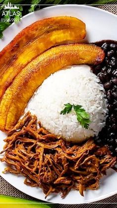 a white plate topped with meat, rice and beans next to banana's on a table