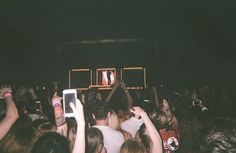 a group of people holding up cell phones at a concert