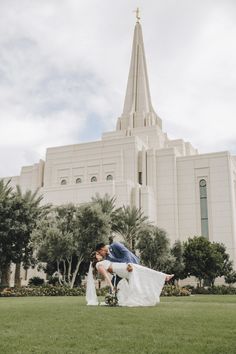 a bride and groom kissing in front of the mormon temple