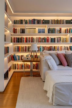 a bed sitting in front of a bookshelf filled with lots of book shelves