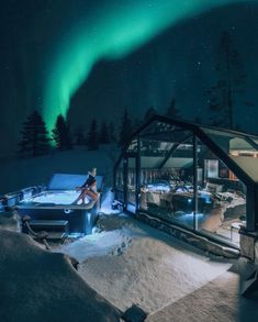 a person sitting on a bench in front of a building with an aurora sign above it