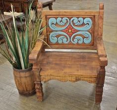 a wooden bench sitting on top of a floor next to a potted plant in front of it