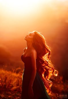 a woman with long hair is looking up at the sky and has her eyes closed