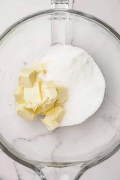 ingredients in a blender for making homemade cheesecakes, including butter and sugar