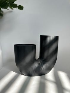 a black vase sitting on top of a white table