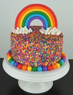 a rainbow cake with sprinkles and candies on top