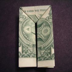 an origami dollar bill folded up to look like it has the word god we trust on it