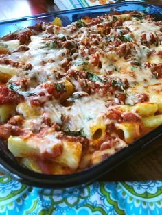 a casserole dish with meat, cheese and sauce in it on a table