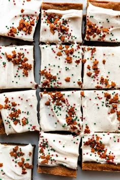 crackers with white frosting and sprinkles are arranged on a baking sheet