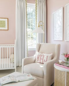 a baby's room with pink walls, white furniture and striped drapes on the windows