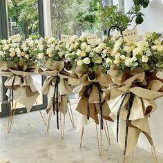 three bouquets of white roses tied together with ribbons