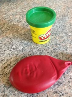 play - doh is sitting on the counter next to a plastic cup and saucer