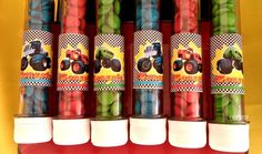 there are many candy candies in the plastic tube with monster trucks on them, as well as green and red gummy bears