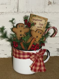 a mug filled with gingerbreads and christmas decorations