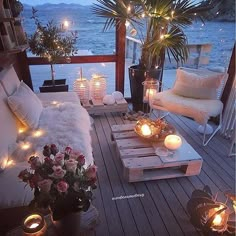 an outdoor deck with candles and flowers on it