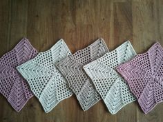 four crocheted squares sitting on top of a wooden floor