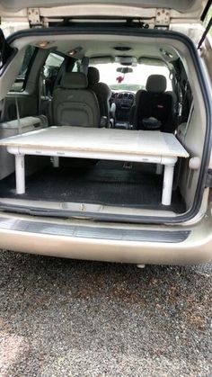 the back end of a car with its trunk open and seats folded down in front