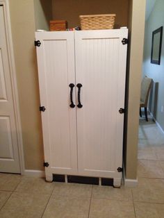 a white cabinet with black handles in a room