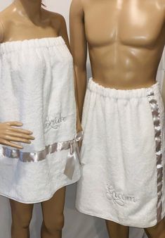 two male mannequins dressed in white towels