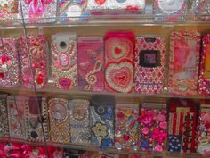 there are many cell phones on display in the store case, all decorated with different designs and colors