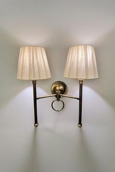 two lamps are on the wall next to each other with one light on it's side