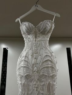 a white dress hanging on a hanger in a room with black and white walls