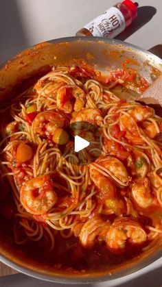 a pan filled with pasta and shrimp in tomato sauce