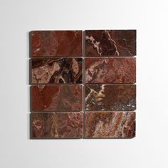 four different types of marble tiles on a white wall, one is red and the other is brown