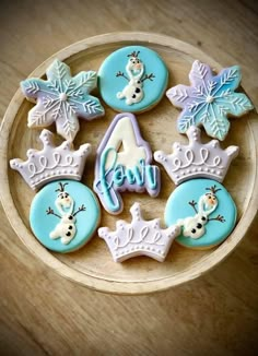 decorated cookies in the shape of crowns and snowflakes on a wooden platter