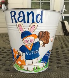 a white bucket with a rabbit holding a baseball glove on it's side and the words rand astros written in blue