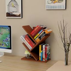 a desk with a computer and bookshelf on it