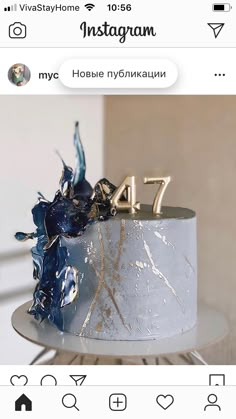 a white cake with blue frosting and gold decorations on top that says instagram