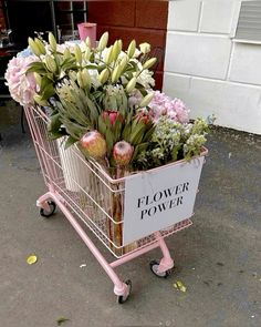 a pink shopping cart filled with lots of flowers