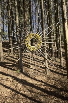 a sculpture in the middle of a forest with many branches and yellow flowers on it