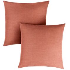 two peach colored pillows sitting next to each other