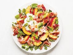 a white plate topped with peaches, bacon and lettuce covered in sour cream