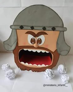 a paper mache with an angry expression on it's face and mouth, surrounded by white balls