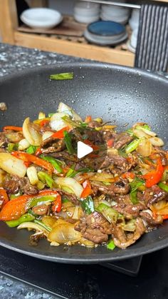 a wok filled with stir fry vegetables and meat