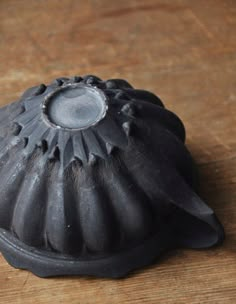 a black object sitting on top of a wooden table