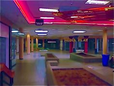 an empty lobby with benches and lights on the ceiling